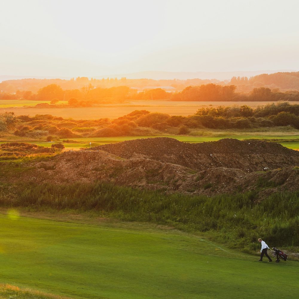 A links golf course seen from the dunes at golden hour